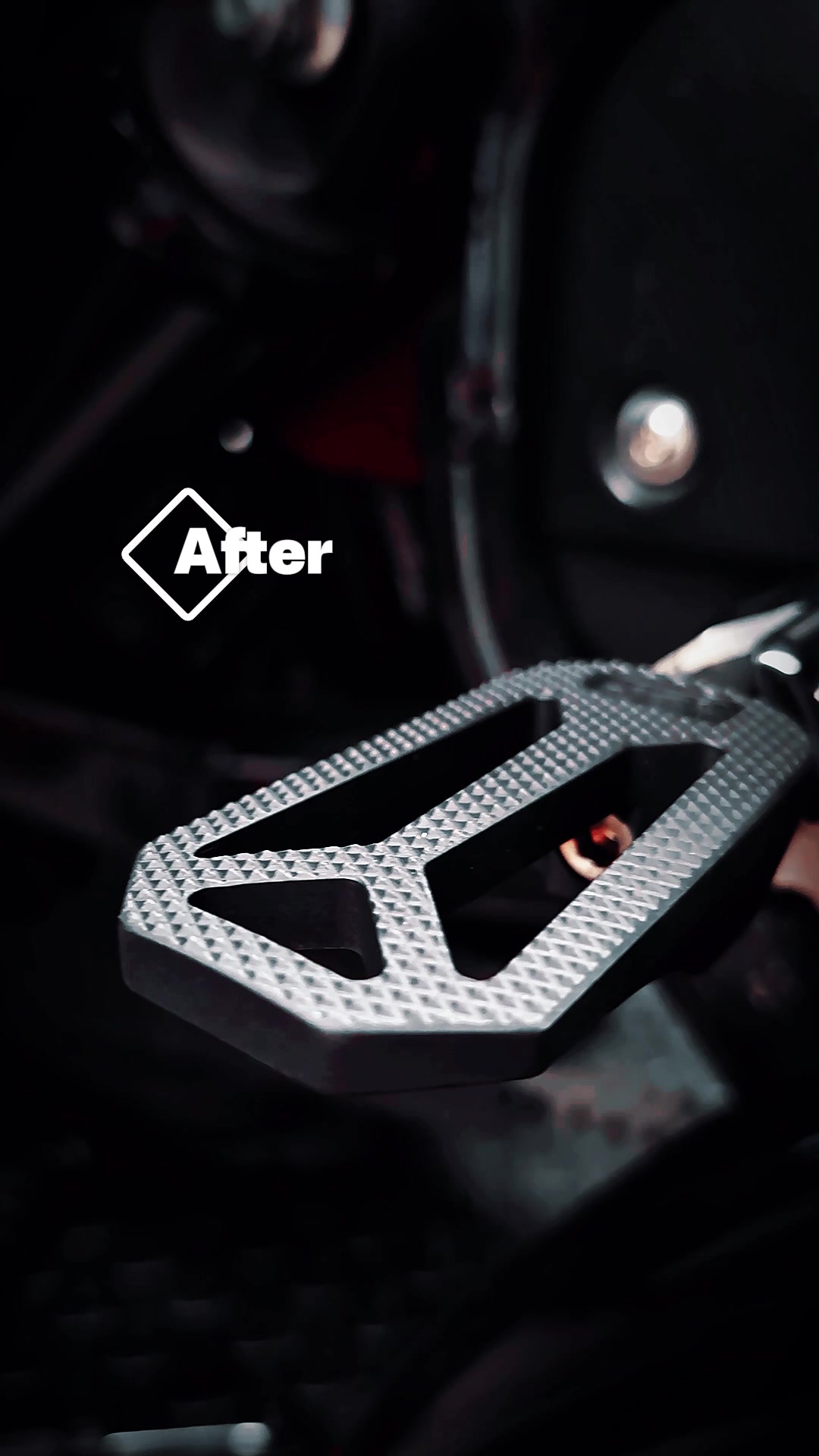 Machined silver Dean Speed footpeg on a motorcycle in low light